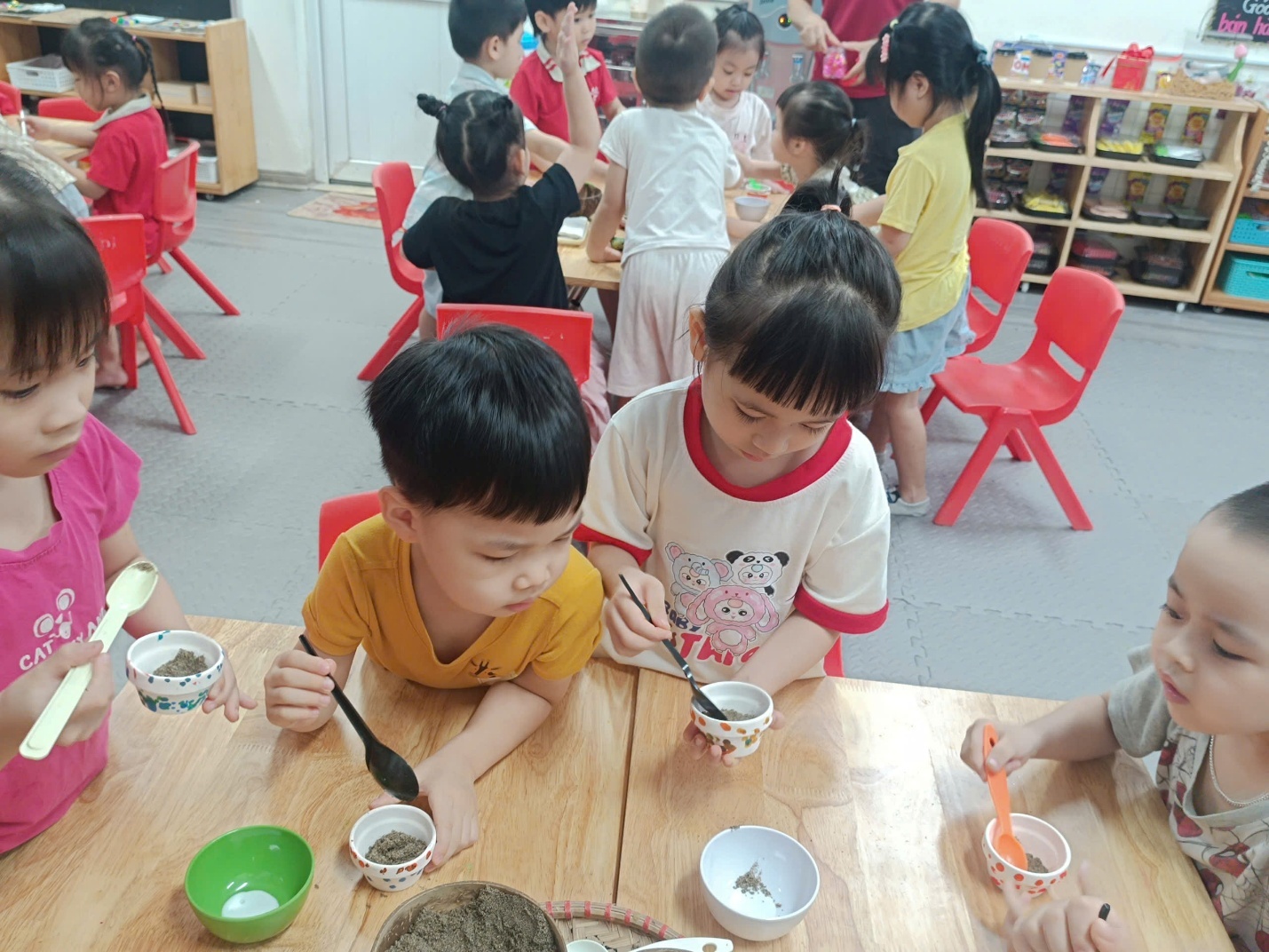 A group of children sitting at a table eating food
AI-generated content may be incorrect.