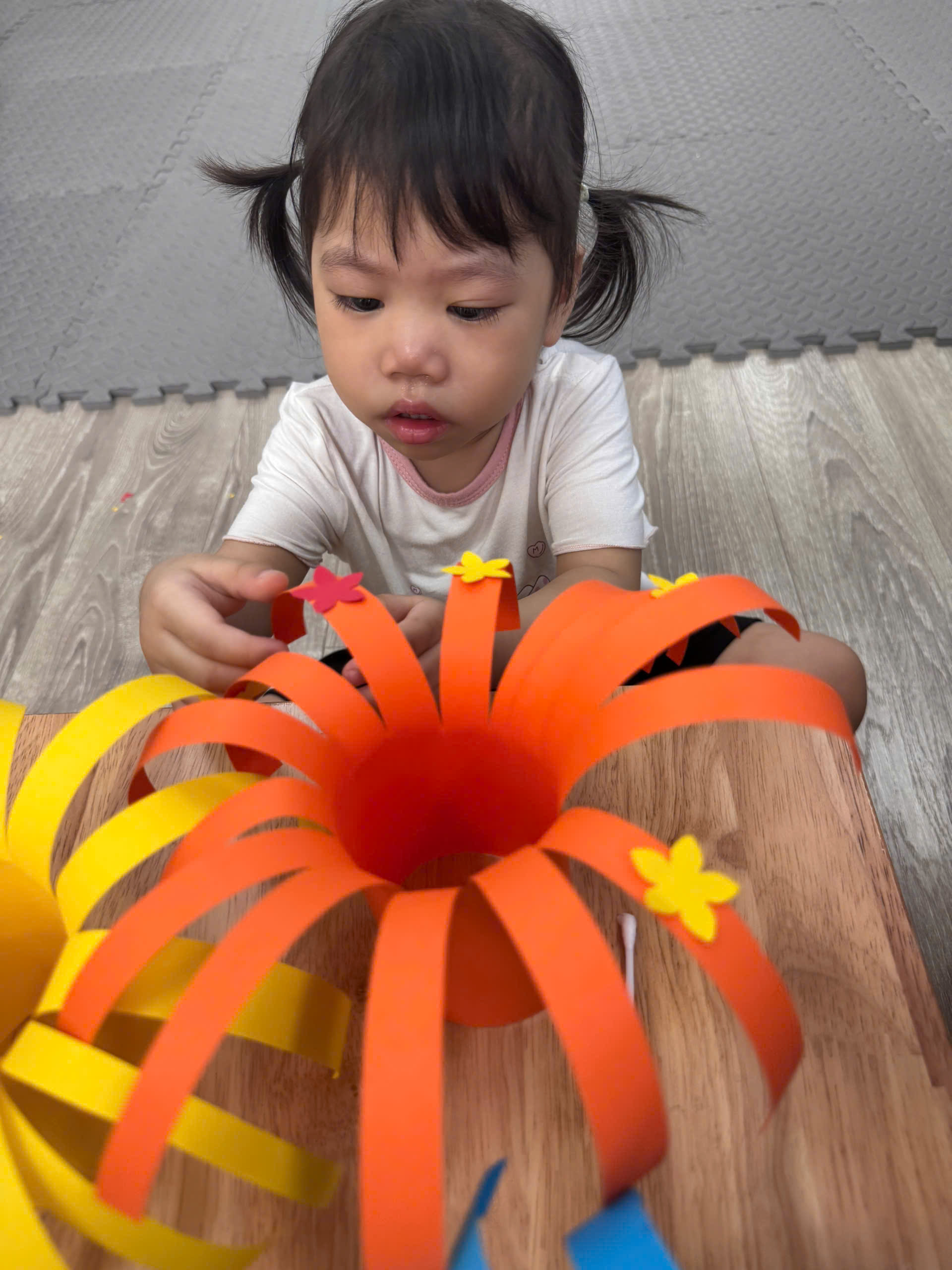 A child making a flower made out of paperAI-generated content may be incorrect.