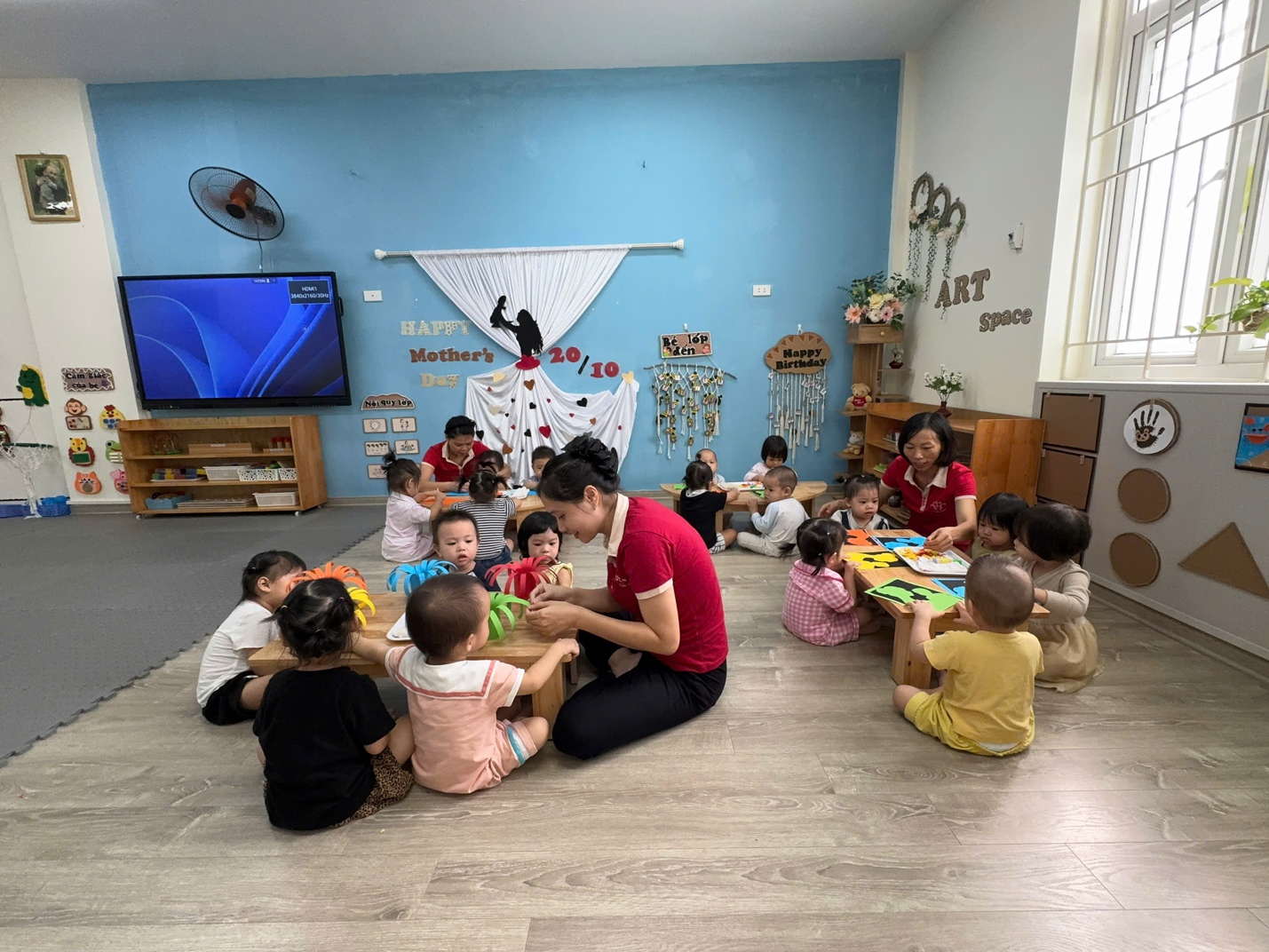 A group of children sitting on the floor in a roomAI-generated content may be incorrect.