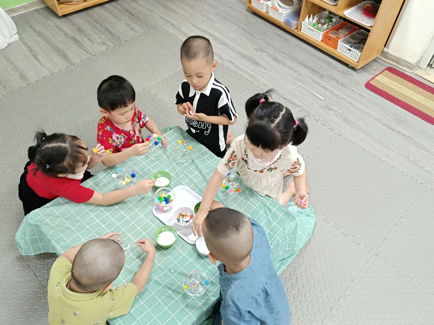 A group of children sitting around a table
AI-generated content may be incorrect.