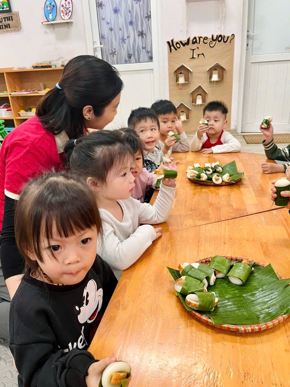 A group of children sitting at a table eating foodAI-generated content may be incorrect.