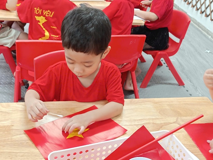 A child in red shirt sitting at a table with a paper star

AI-generated content may be incorrect.