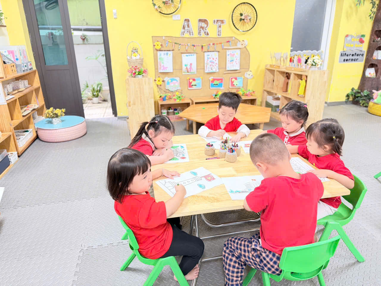 A group of children sitting at a tableAI-generated content may be incorrect.