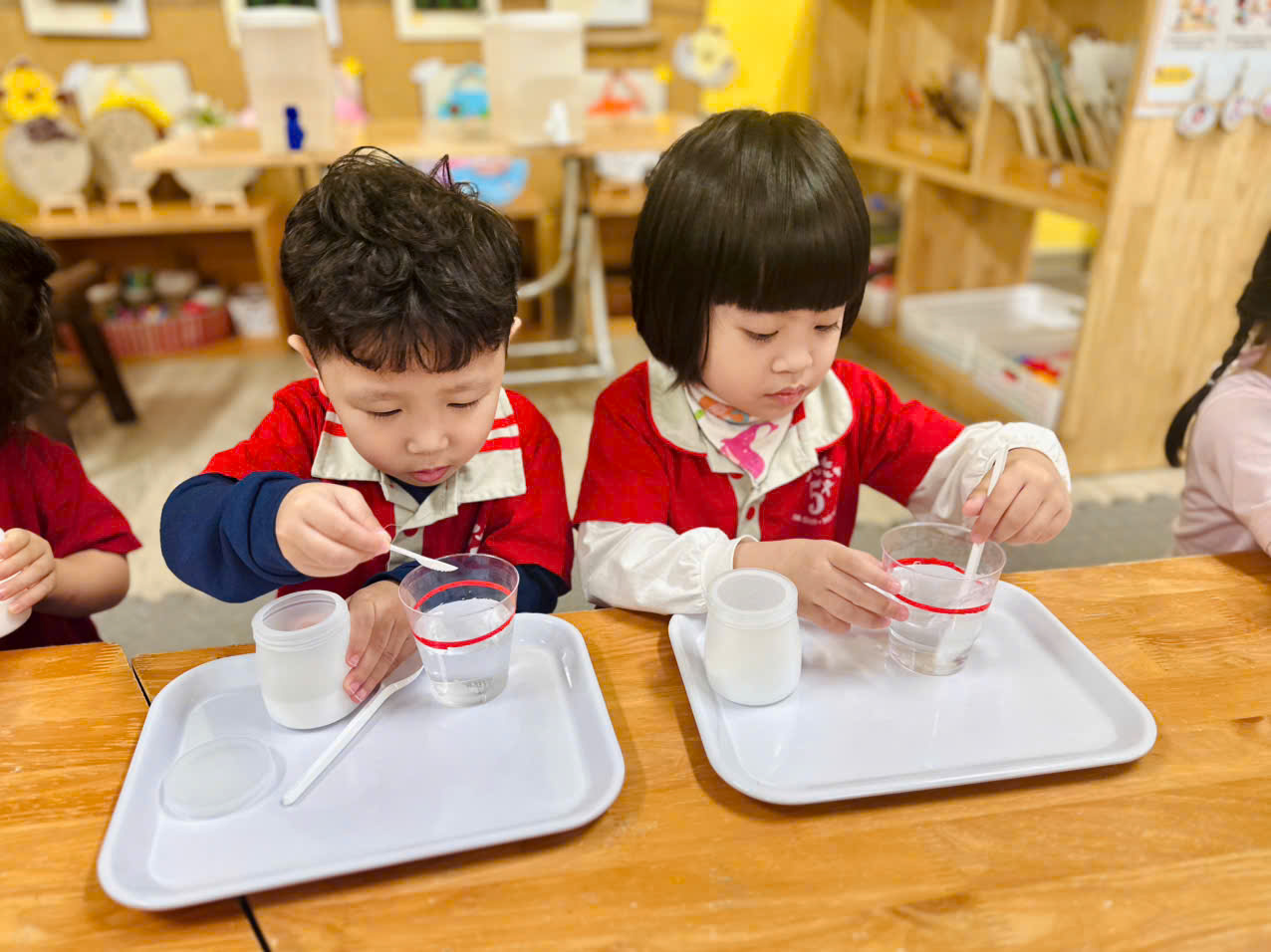 A couple of children painting on a tableAI-generated content may be incorrect.