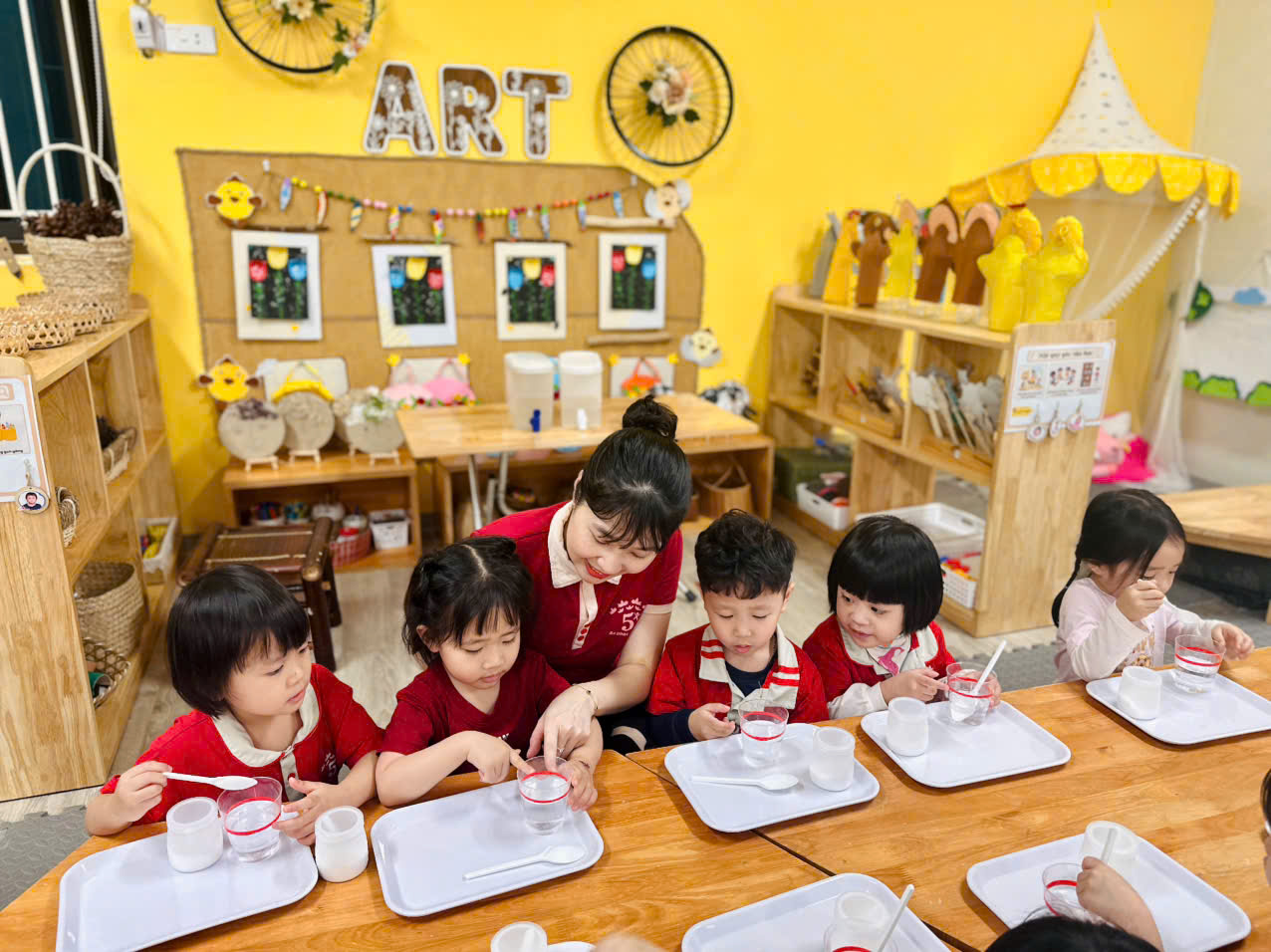 A group of children sitting at a tableAI-generated content may be incorrect.