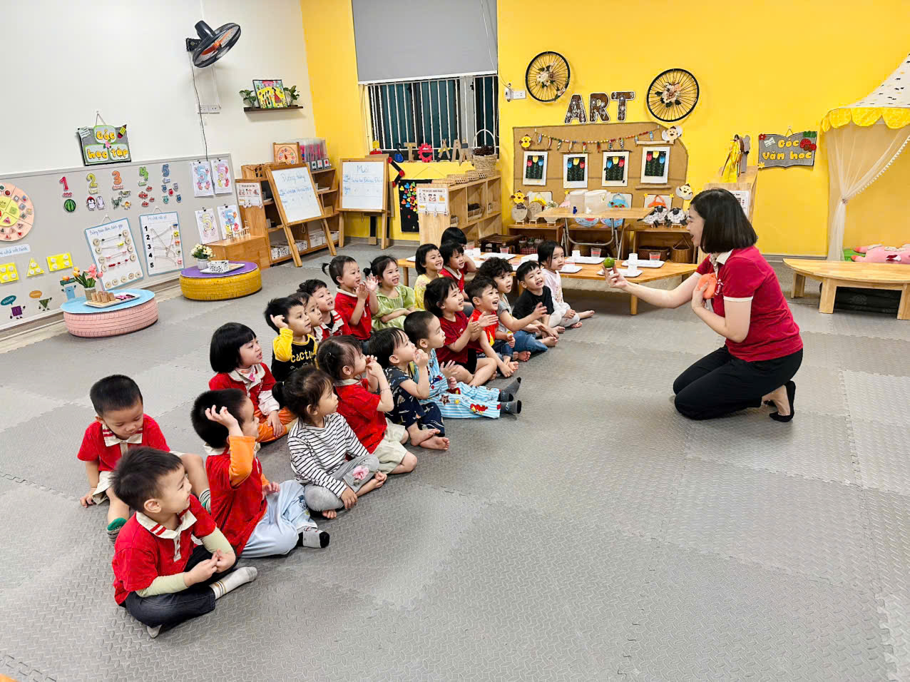 A group of children sitting on the floor in a classroomAI-generated content may be incorrect.
