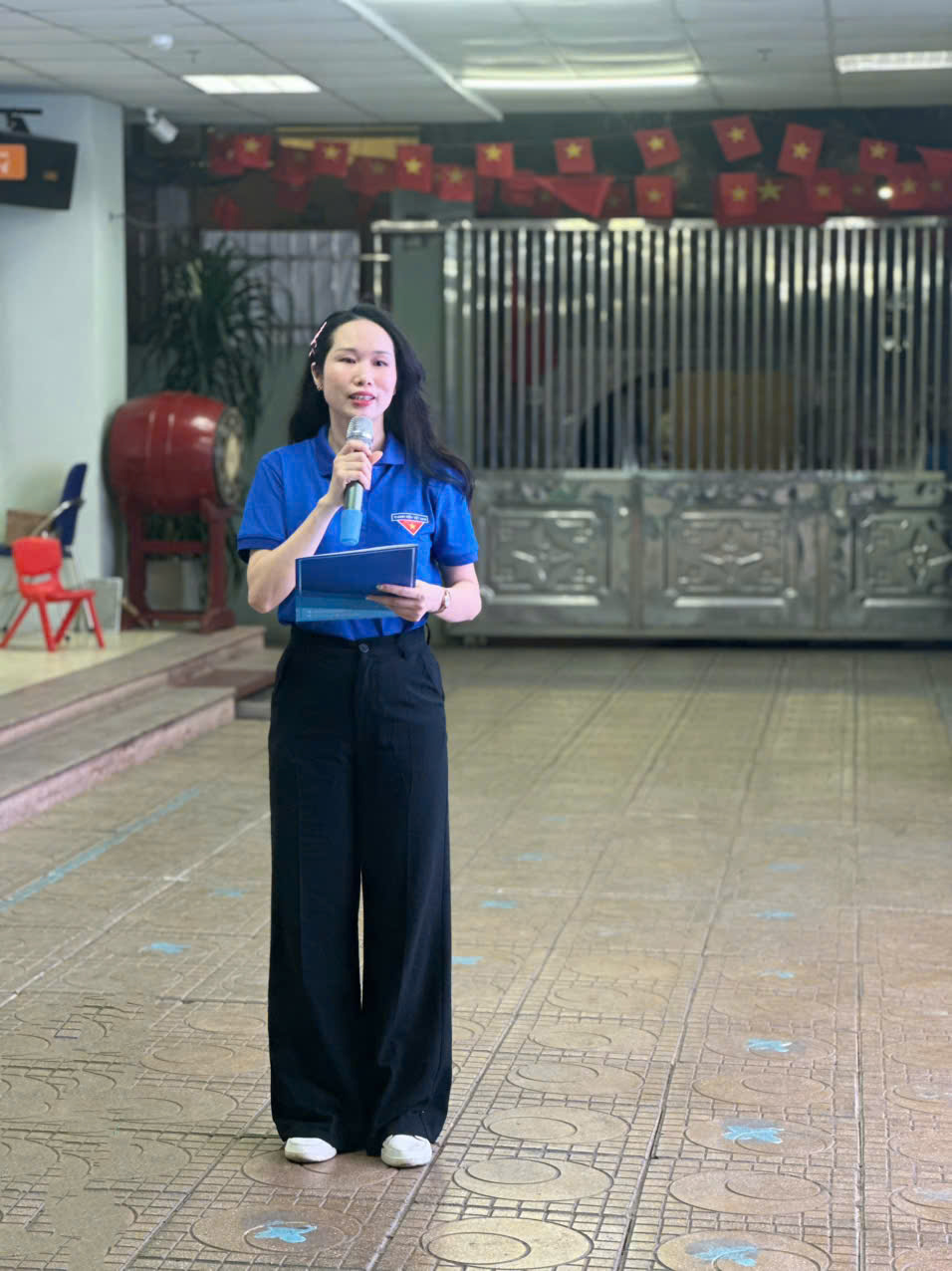 A person standing in a room holding a microphoneAI-generated content may be incorrect.