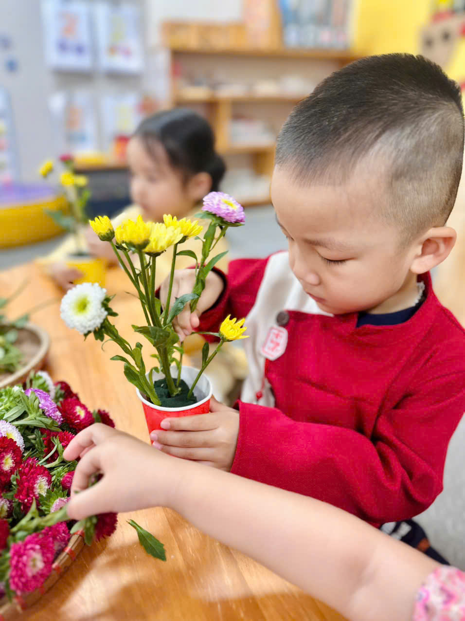 A young child holding a small cup with flowersAI-generated content may be incorrect.