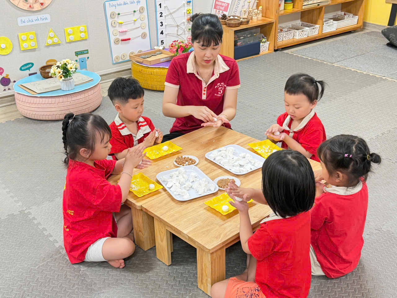 A group of children sitting around a tableAI-generated content may be incorrect.