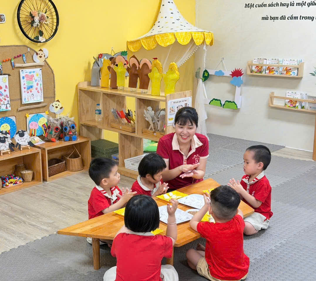 A group of children sitting around a table in a classroomAI-generated content may be incorrect.